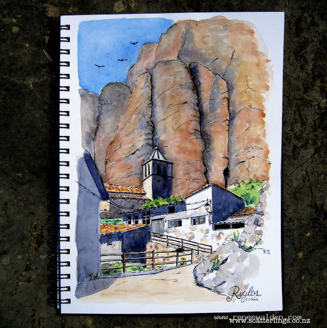 The town of Riglos is dwarfed by the large conglomerate towers behind and home to many vultures.