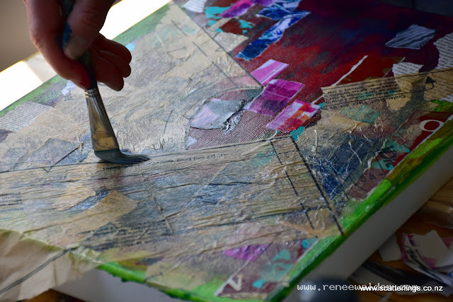 Heidi adding collage papers at the beginning of a mixed media piece